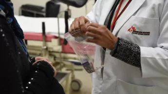 Ärztin überreicht Medikamente