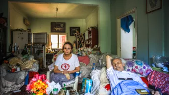 Alter Mann mit Tochter in vollgestellter Wohnung 