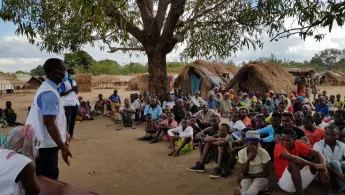 Unsere Mitarbeitenden sprechen mit Menschen in einem Vertriebenen-Camp.