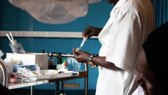 Pflegekraft bereitet eine Spritze vor