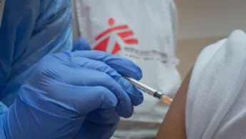 Medizinisches Personal impft eine Person gegen Covid-19. 