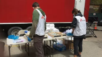 Mitarbeiter*innen stellen Hygieneprodukte vor öffentlichen Duschen bereit