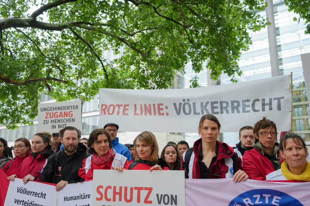 Menschen demonstrieren vor Auswärtigem Amt