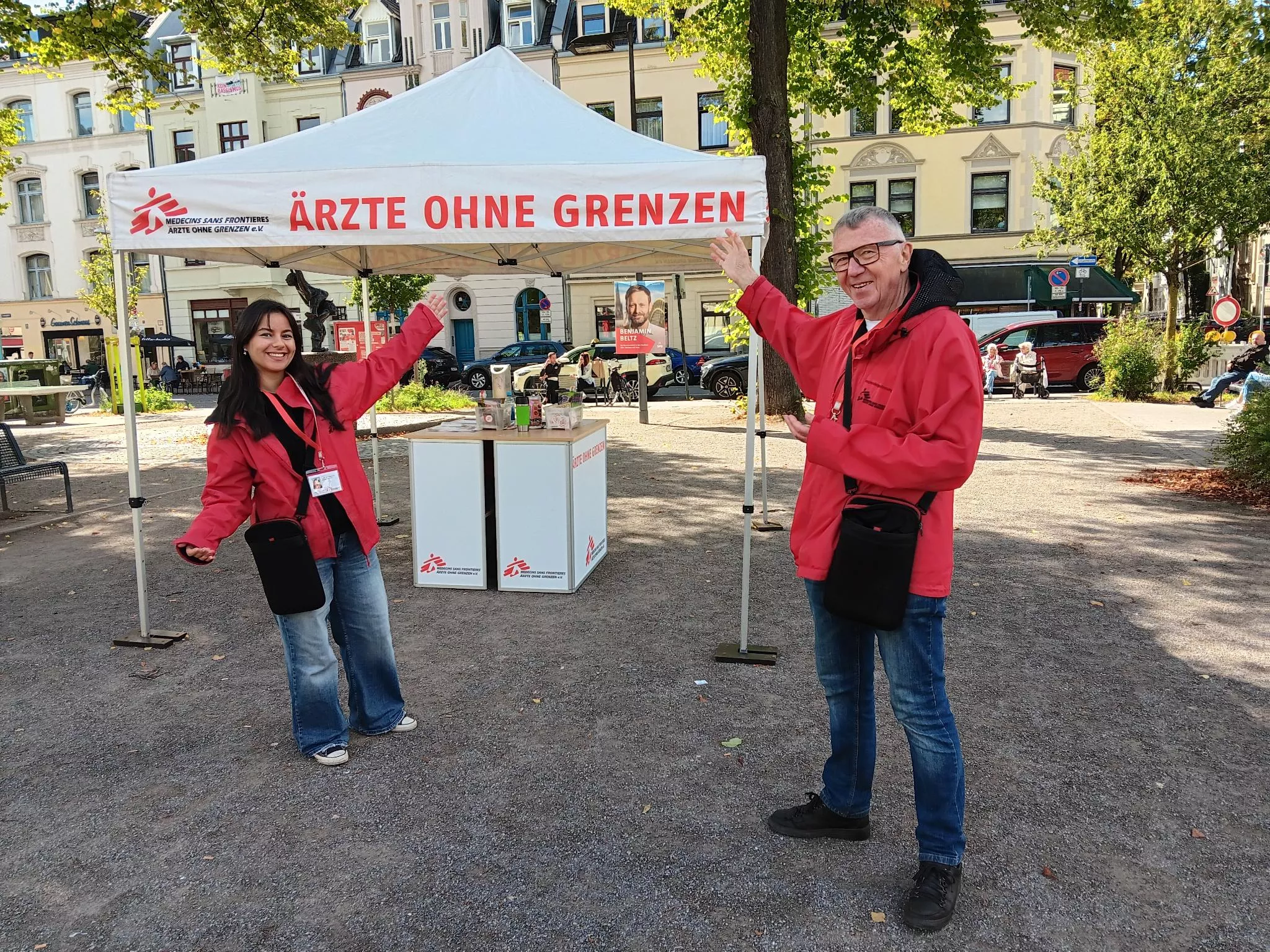 Zwei unserer Mitarbeiter*innen zeigen auf einen unserer Info-Stände.
