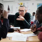 Sprachunterricht für Asylsuchende: Lehrer und Schüler sitzen an Tisch