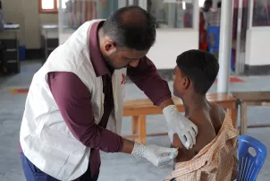 Ein Arzt impft einen Patienten