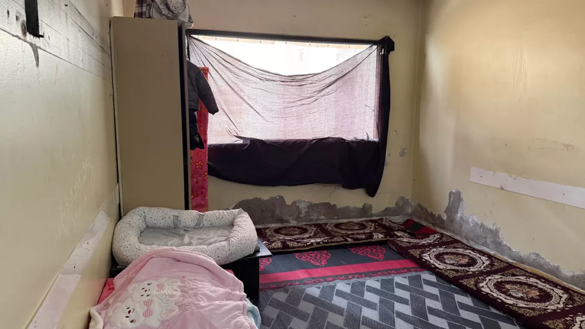 Ein Zimmer, indem ein Fenster mit einem Tuch abgehängt ist.