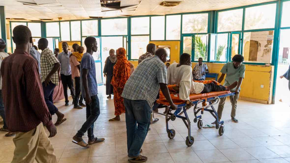 Eingangsbereich von Krankenhaus, Patient auf Bett wird transportiert