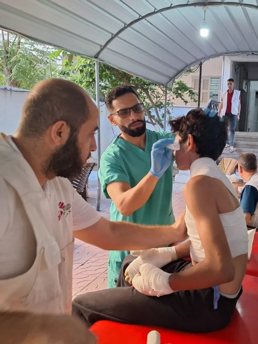 Zwei Pfleger versorgen einen Jungen mit Verbrennungen am Oberkörper.