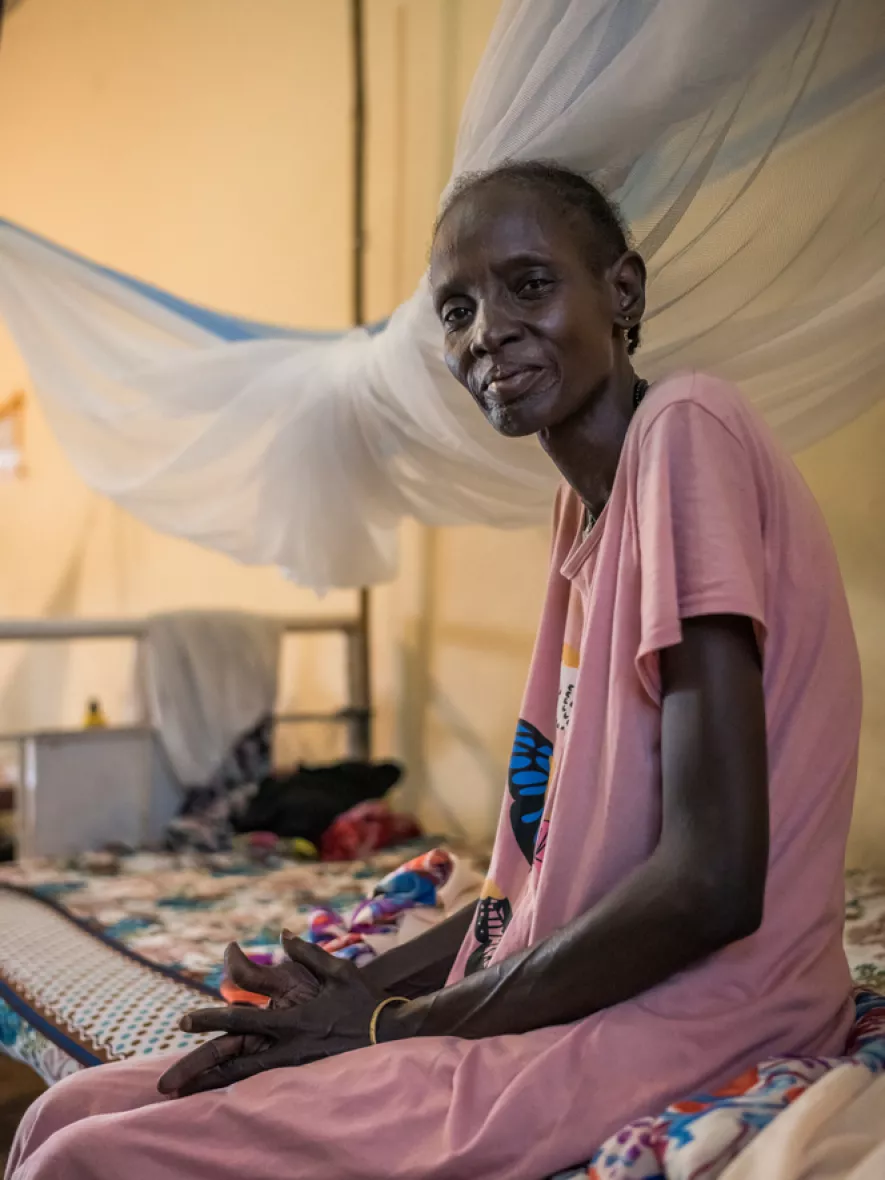 Frau sitzt auf Krankenhausbett