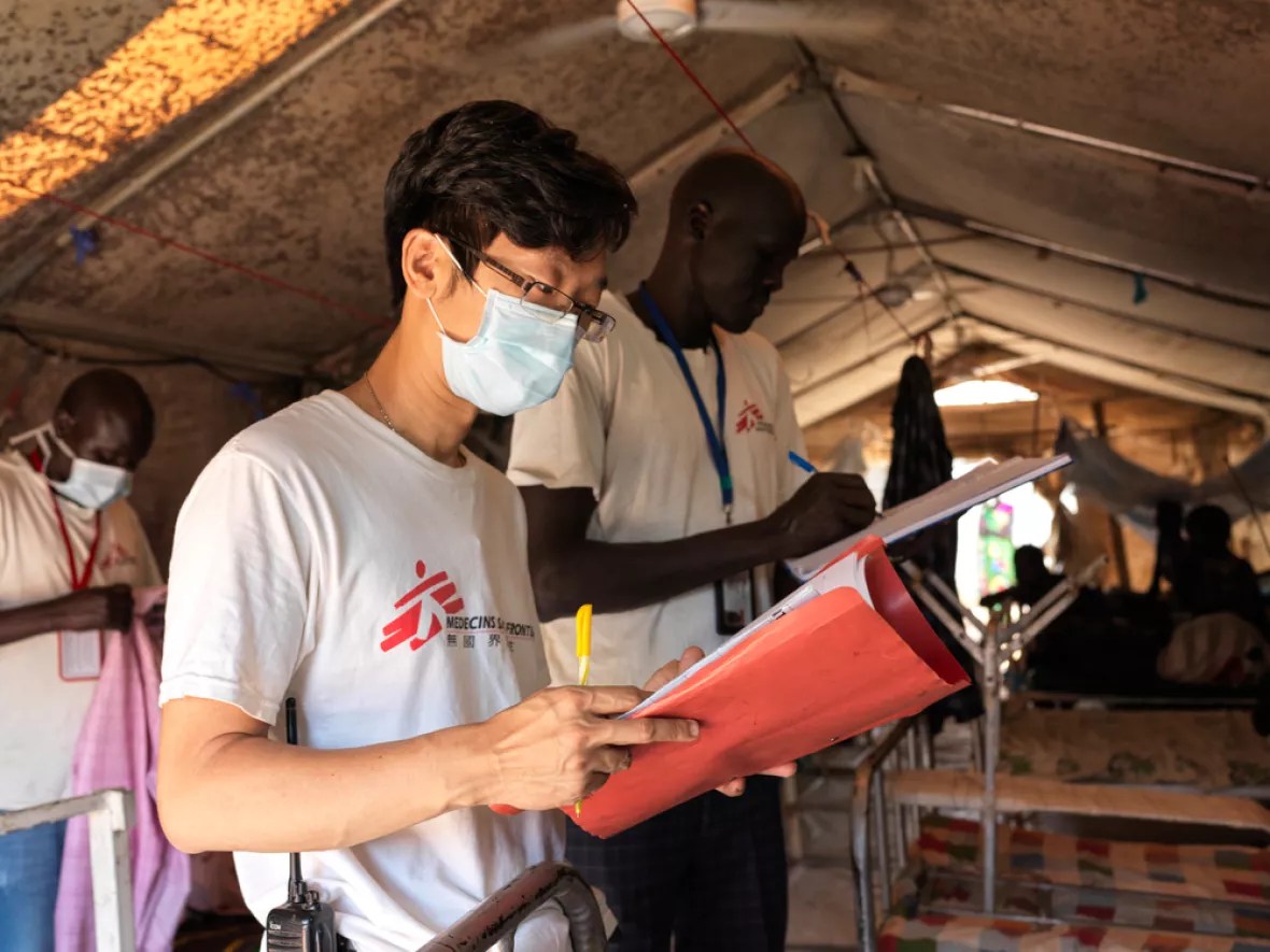 Arbeit im Projekt: Mitarbeitende stehen an Betten und machen Notizen