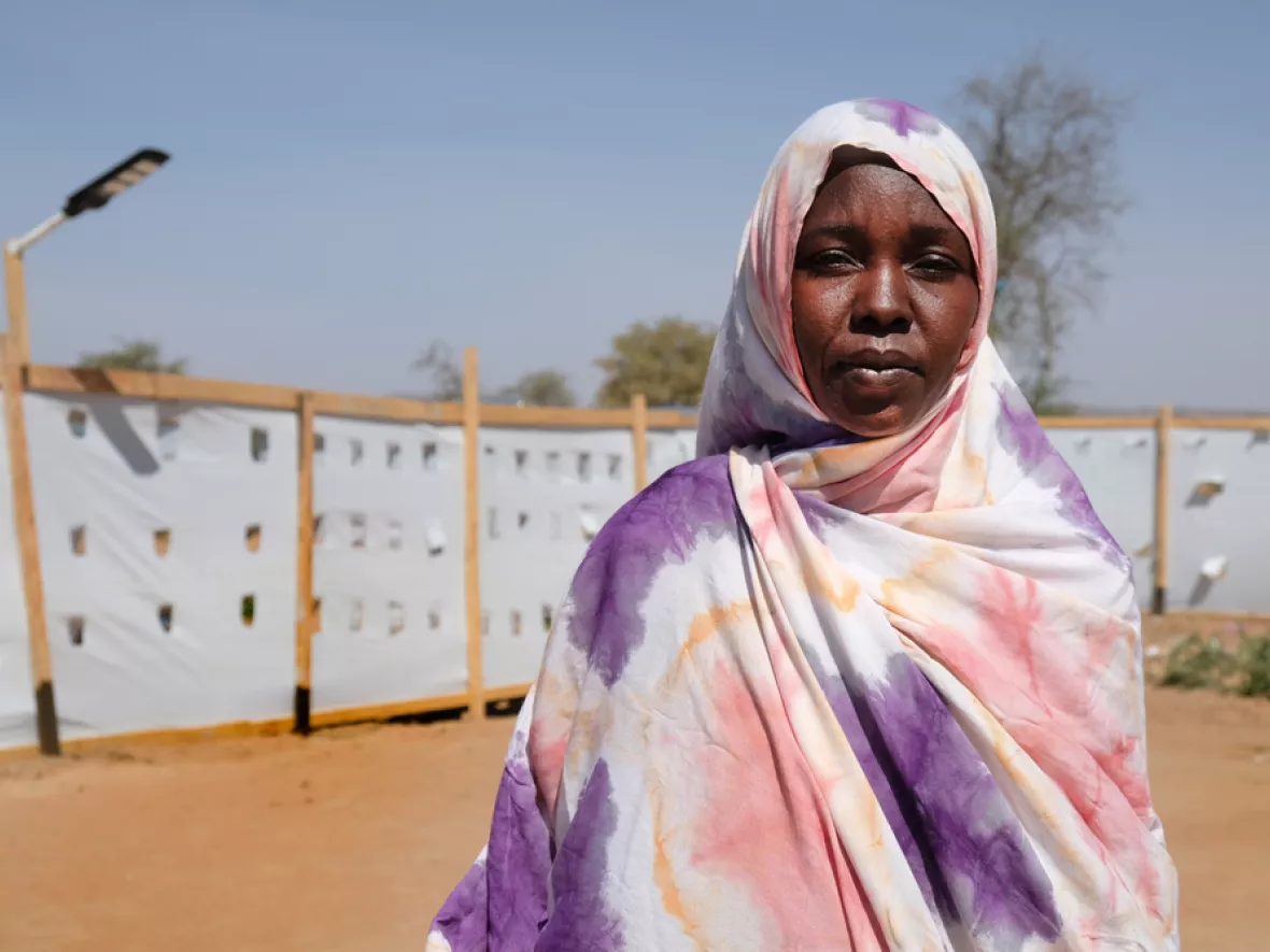 Nadia Omar Mohammad vor Plastikwand in Geflüchtetencamp