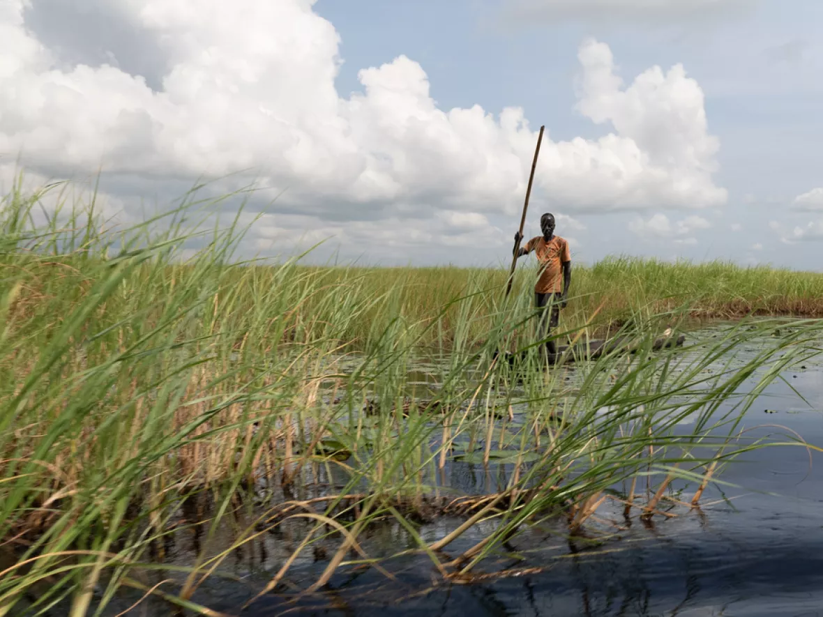  Ein Mann steht auf einem Kanu in der Nähe der Stadt Old Fangak. 
