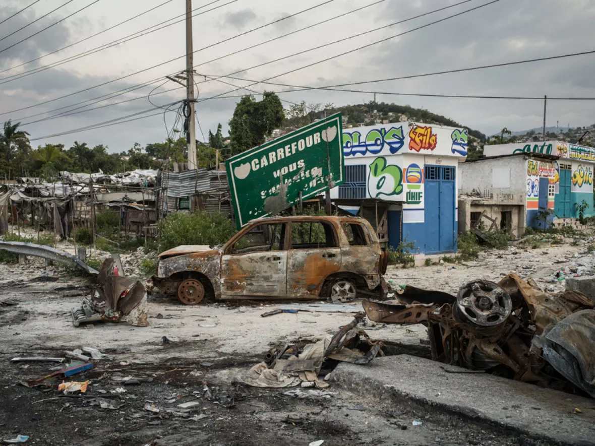 Zerstörte Straße, Müll und ausgebrannte Autos