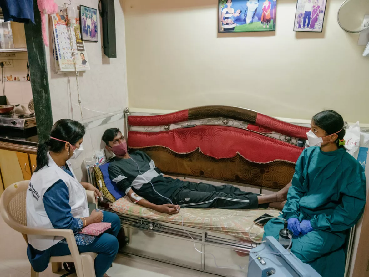 Ein Tuberkulose Patient mit zwei Mitarbeiterinnen von Ärzte ohne Grenzen bei der Behandlung