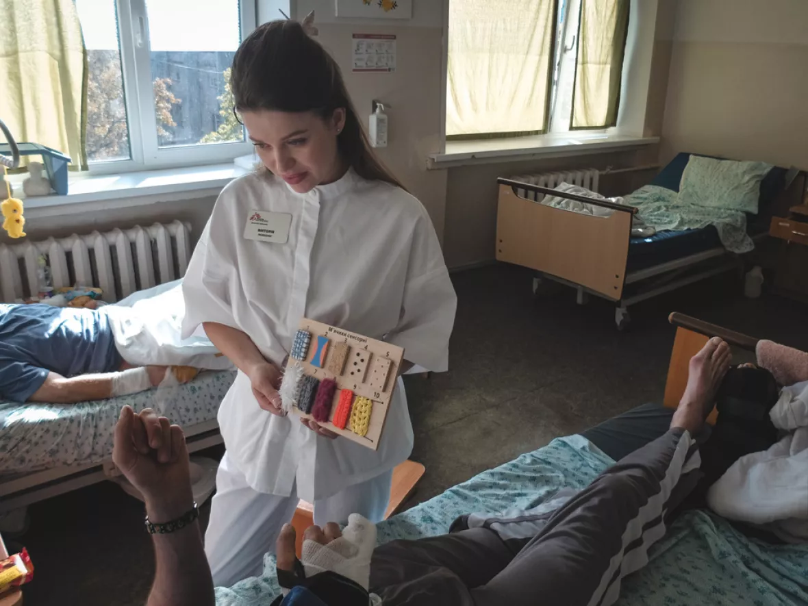 Eine Psychologin von Ärzte ohne Grenzen macht mit einem Patienten eine Rehabilitationsübung.