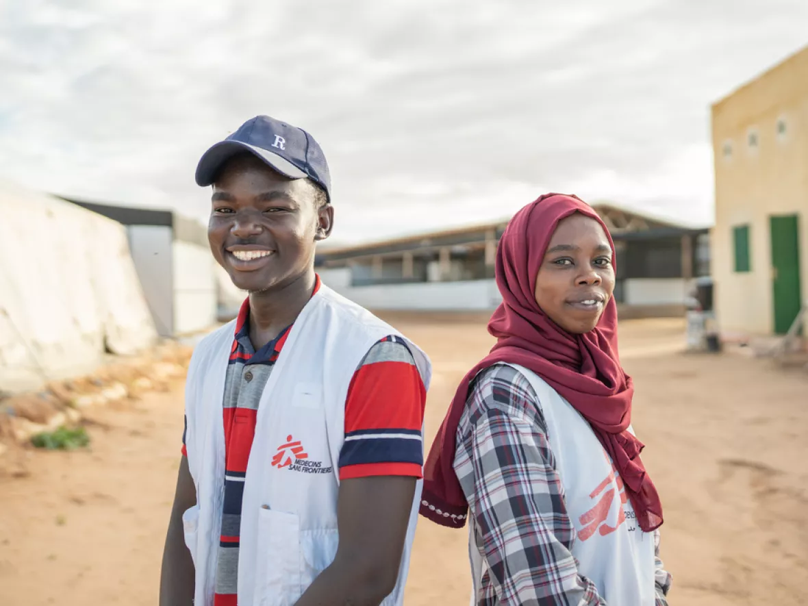 Zwei Personen mit einer weste von Ärzte ohne Grenzen blicken lächelnd in die Kamera