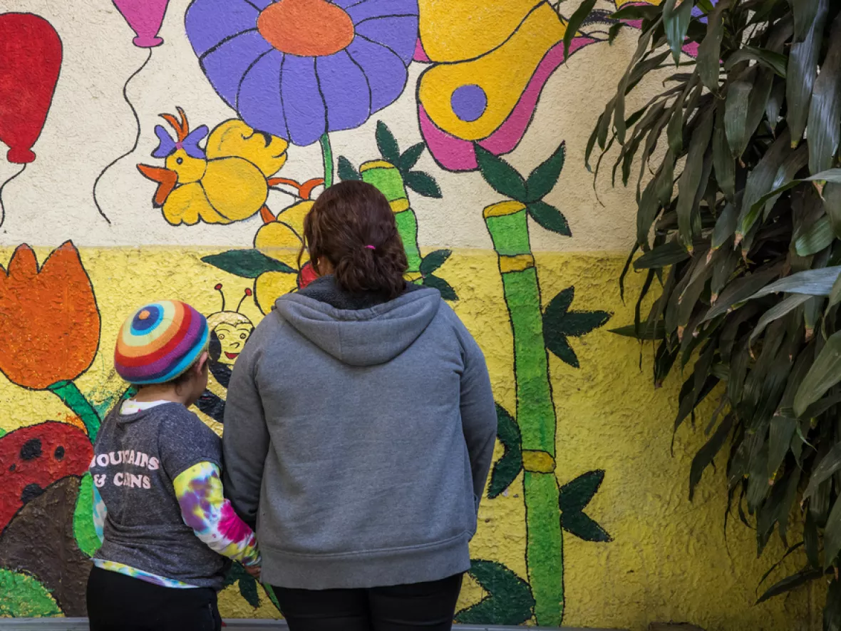 Mexiko: Mutter und Tochter vor Wandgemälde
