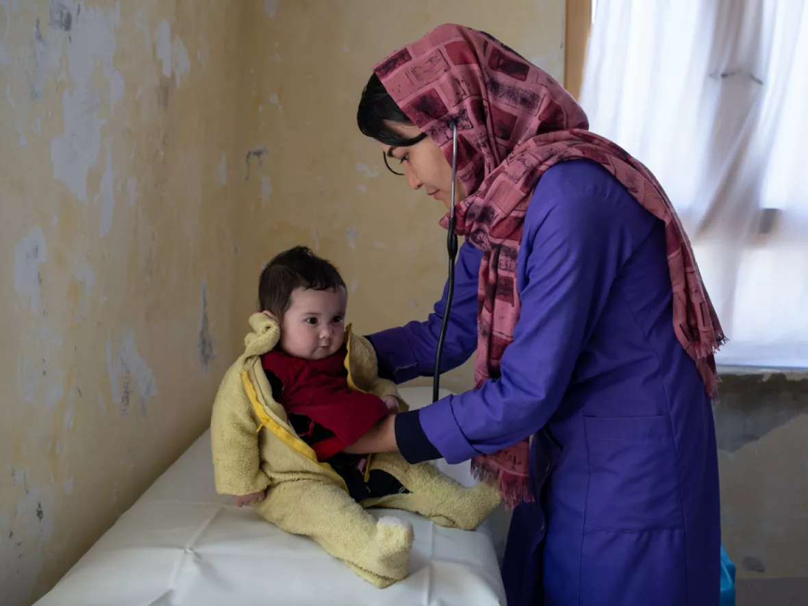 Frau hört Kleinkind mit Stethoskop ab