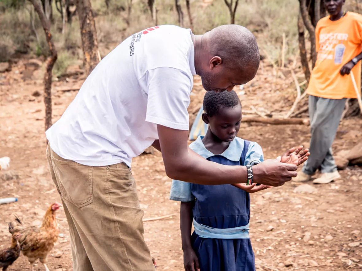 Ein Mitarbeiter begutachtet die durch einen Schlangenbiss entstandene Wunde eines Kindes. 