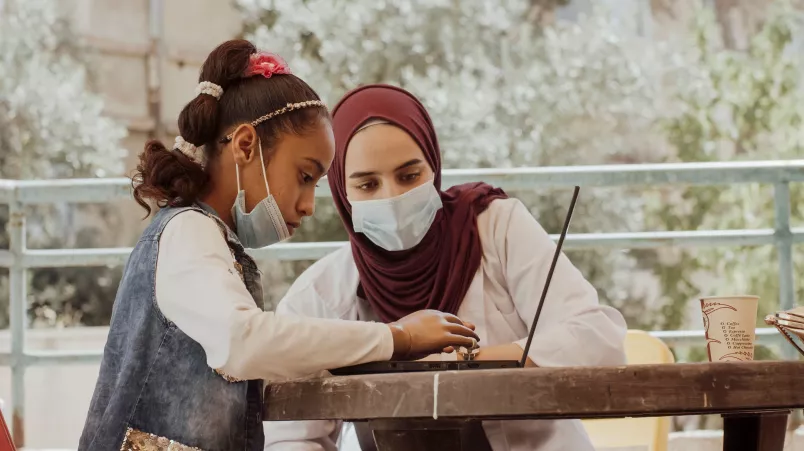 Zwei Personen sitzen am Tisch