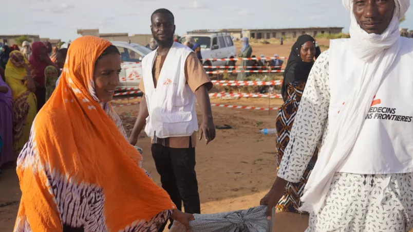 Frau erhält Nothilfe-Kit.