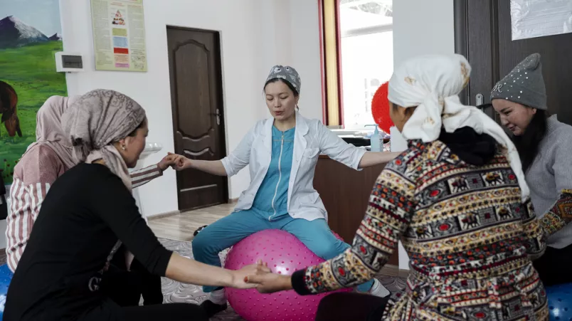 Eine Hebamme leitet einen Geburtsvorbereitungskurs