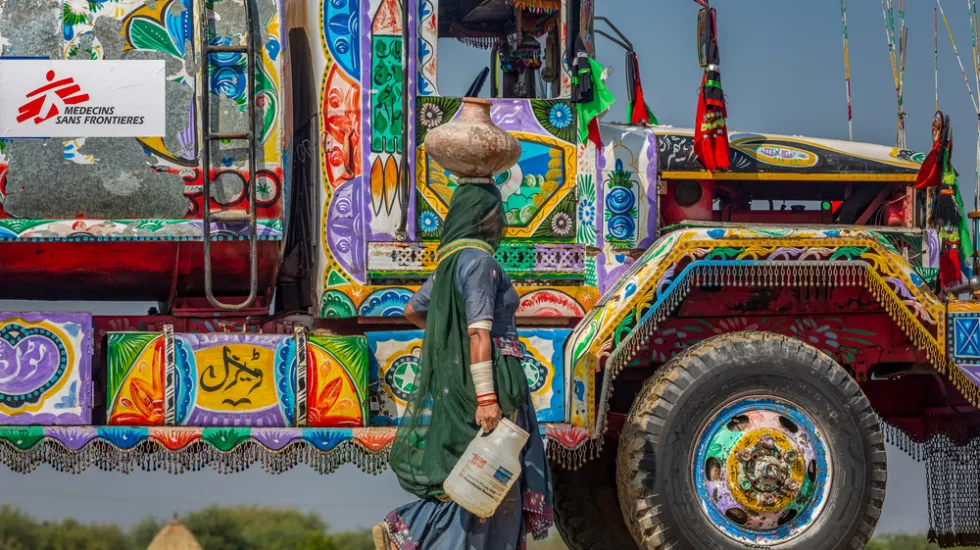 Eine Frau mit Wasserkanister vor unserem Wassertruck