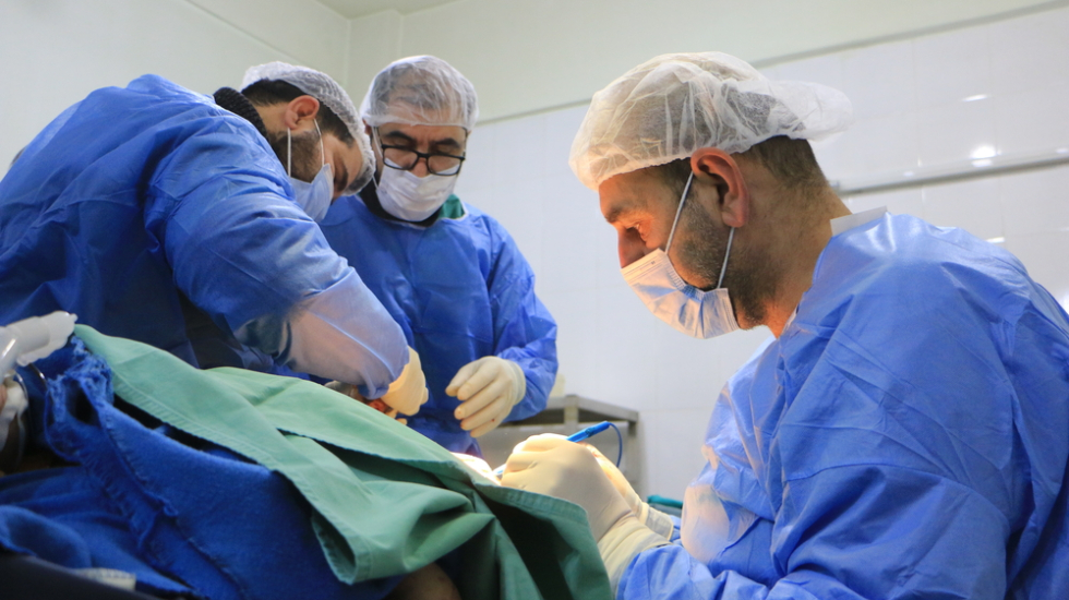 Ein Team von Chirurgen operiert einen Patienten, der im Erdbeben verletzt wurde.