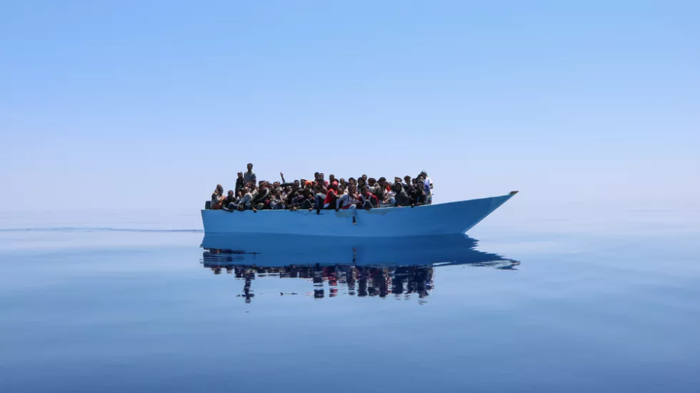 Ein mit Menschen überladenes Schiff in Seenot