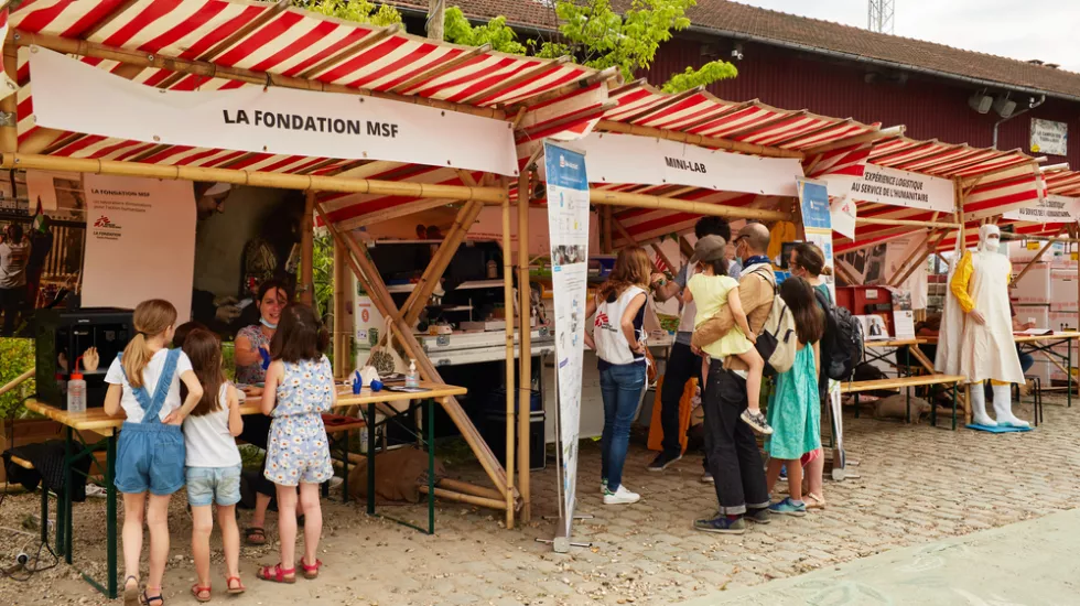 Kinder vor Infostand zu verschiedenen Berufen von Ärzte ohne Grenzen.