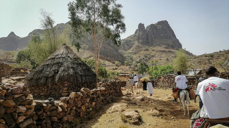 Mitarbeitende reisen auf Eseln durchs Gebirge.
