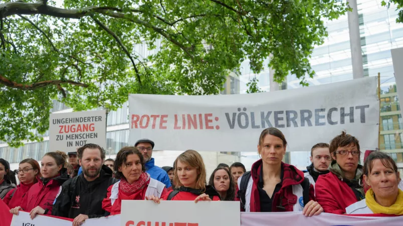 Menschen mit Plakaten demonstrieren vor dem Auswärtigem Amt in Berlin