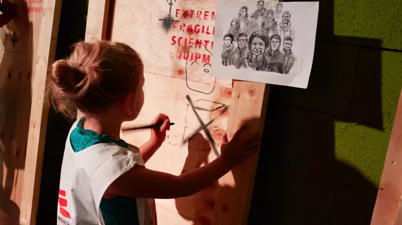 Ein Schulkind malt ein Bild.