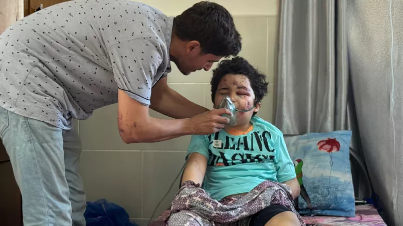 Kleiner Junge mit Verletzungen wird in Bett versorgt