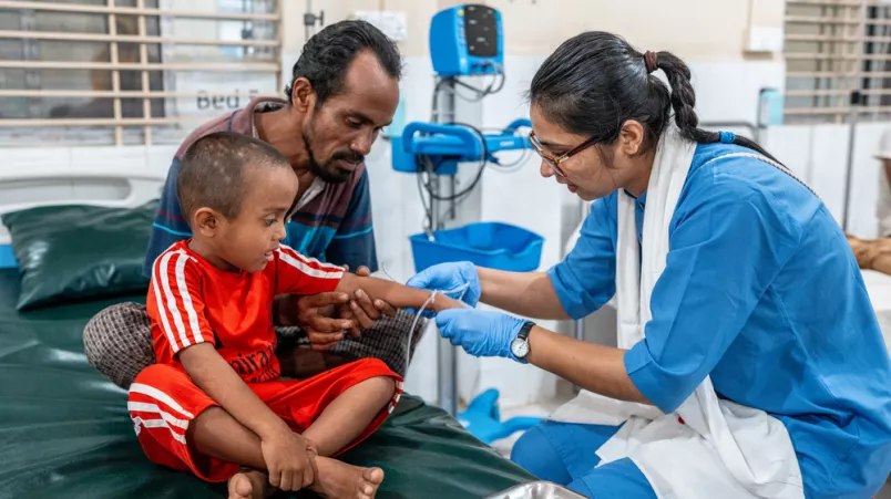 Ein kleiner Junge wird von einer Krankenschwester behandelt.