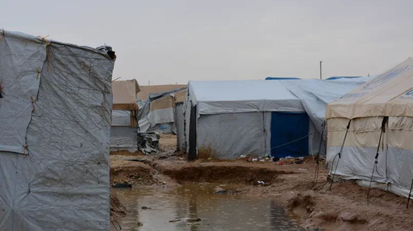 Schlammiges Wasser steht zwischen zwei Zelten.