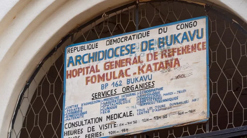 Schild mit Informationen über Öffnungszeiten und Dienstleistungen eines Krankenhauses