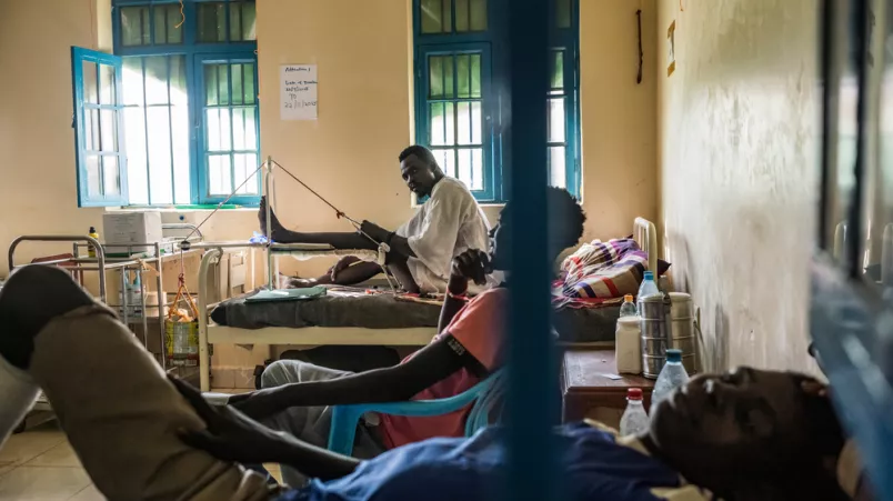 Drei Patient*innen, einer zieht an Seil, das seine Beinposition anpasst