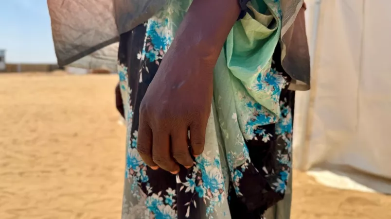 Nahaufnahme der Hand einer Frau vor einem Zelt in einem Vertriebenencamp.