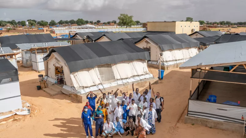 Gruppe Mitarbeitender zwischen Behandlungszelten