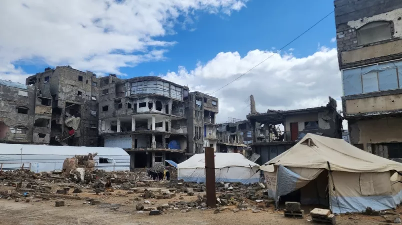 Zelte inmitten von zerstörten Wohnhäusern.