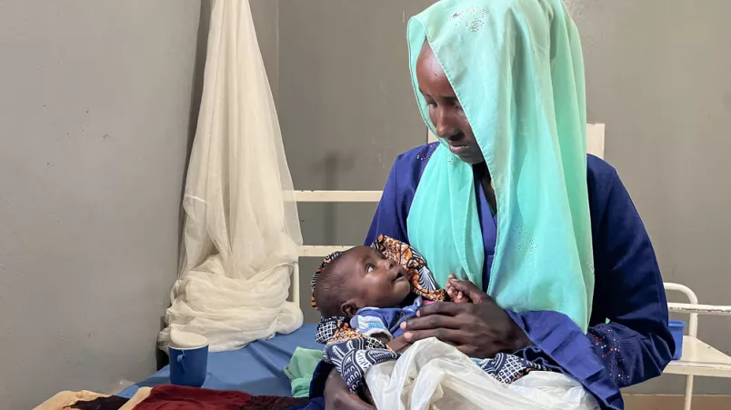 Säugling in Arm von Mutter