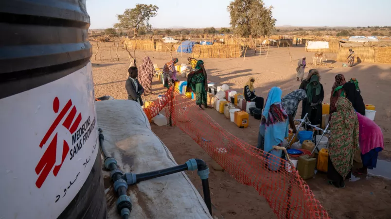Menschen stehen an bei Wasserausgabe