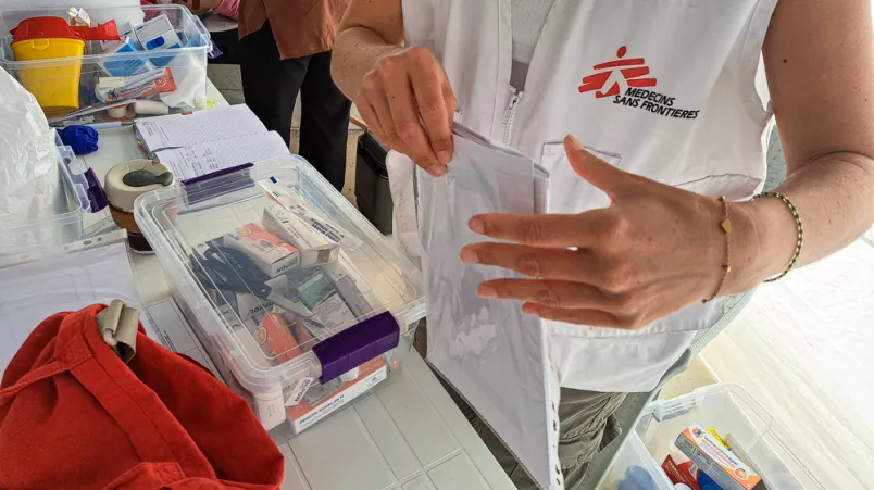 Mitarbeiterin legt Dokumente an Arbeitstisch ab