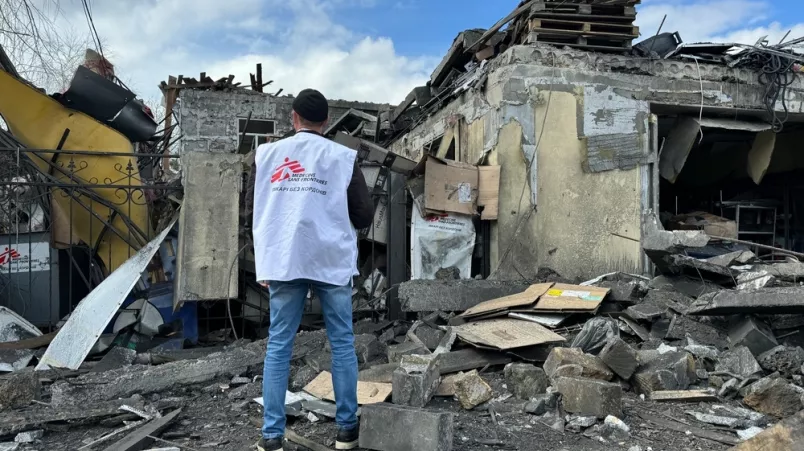 Mitarbeiter steht vor zerstörtem Gebäude