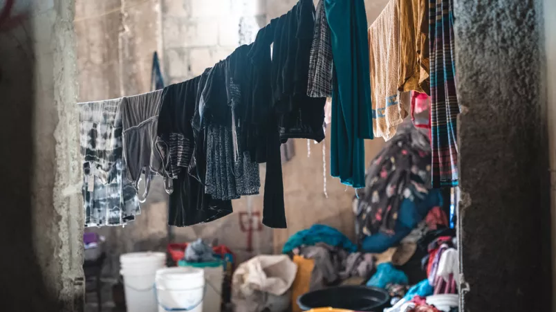 Gewaschene Kleidung, Lebensmittel und Kochuntensilien in einem Raum