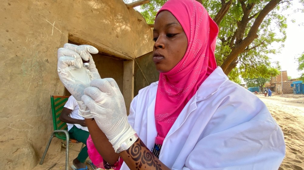Eine medizinische Mitarbeiterin bereitet eine Spritze mit einer Impfung vor