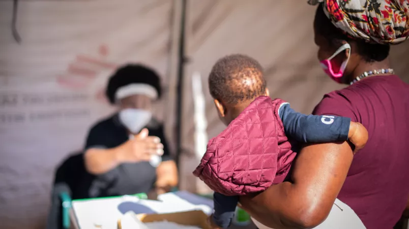 An verschiedenen Punkten außerhalb der Kliniken erhalten die Ankommenden Informationen und werden auf Symptome von Covid-19 untersucht.