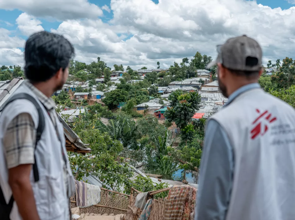 2 Mitarbeitende blicken über das Camp.